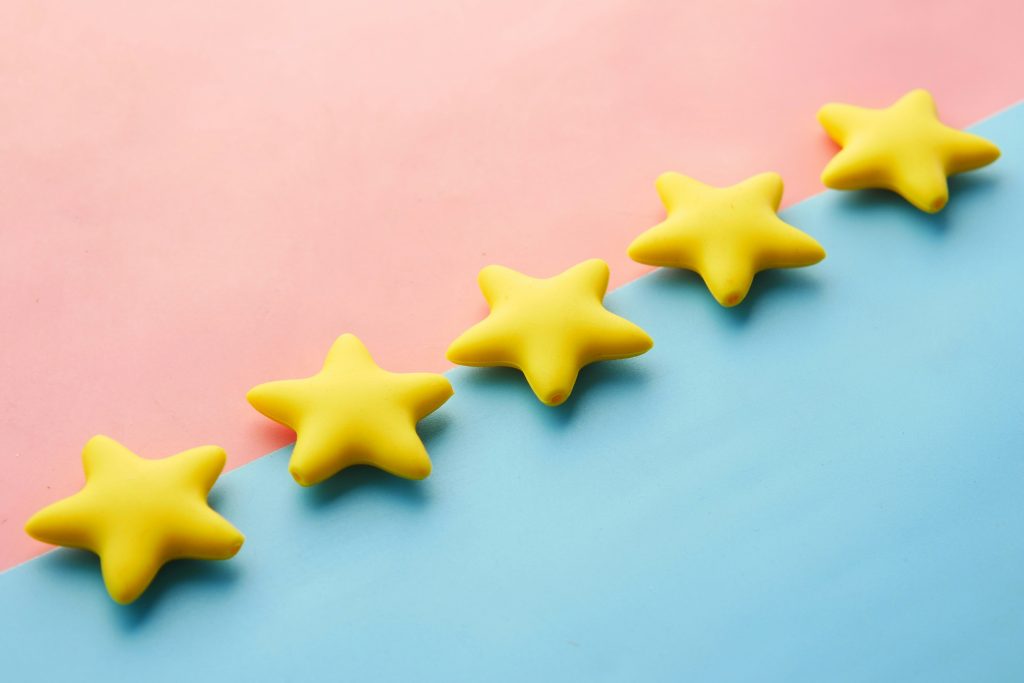 five yellow stars lines against a pink and blue background