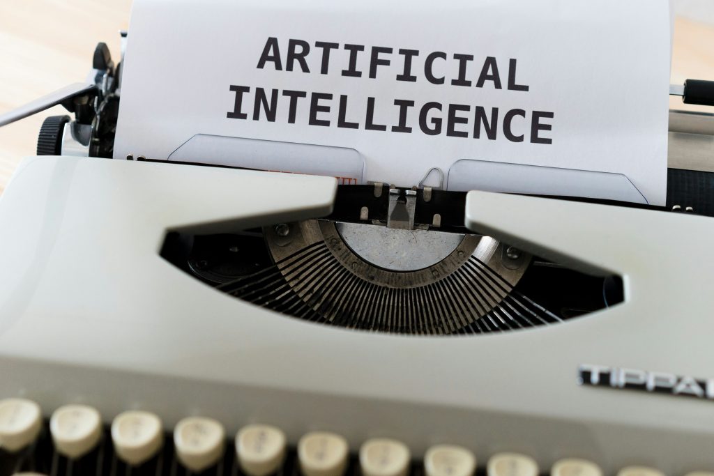 typewriter with page that reads "artificial intelligence"