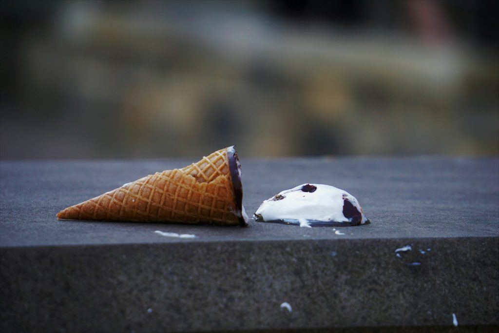 an ice cream cone has fallen on the ground, spilling the ice cream