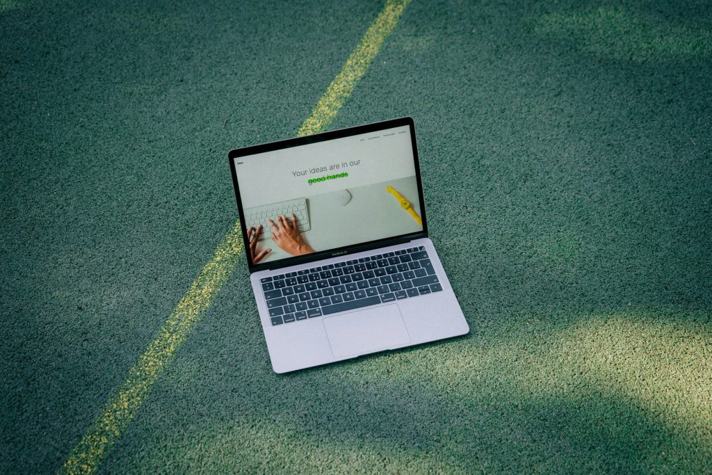 a laptop showing a website sits on the ground