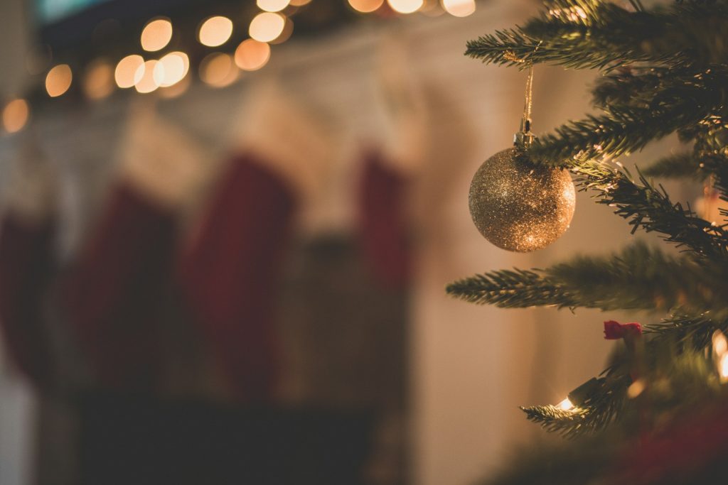 a golden ornament hangs from a Christmas tree limb